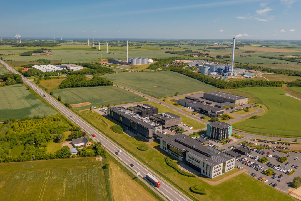Aerial view of an industrial park with a wind farm in the background